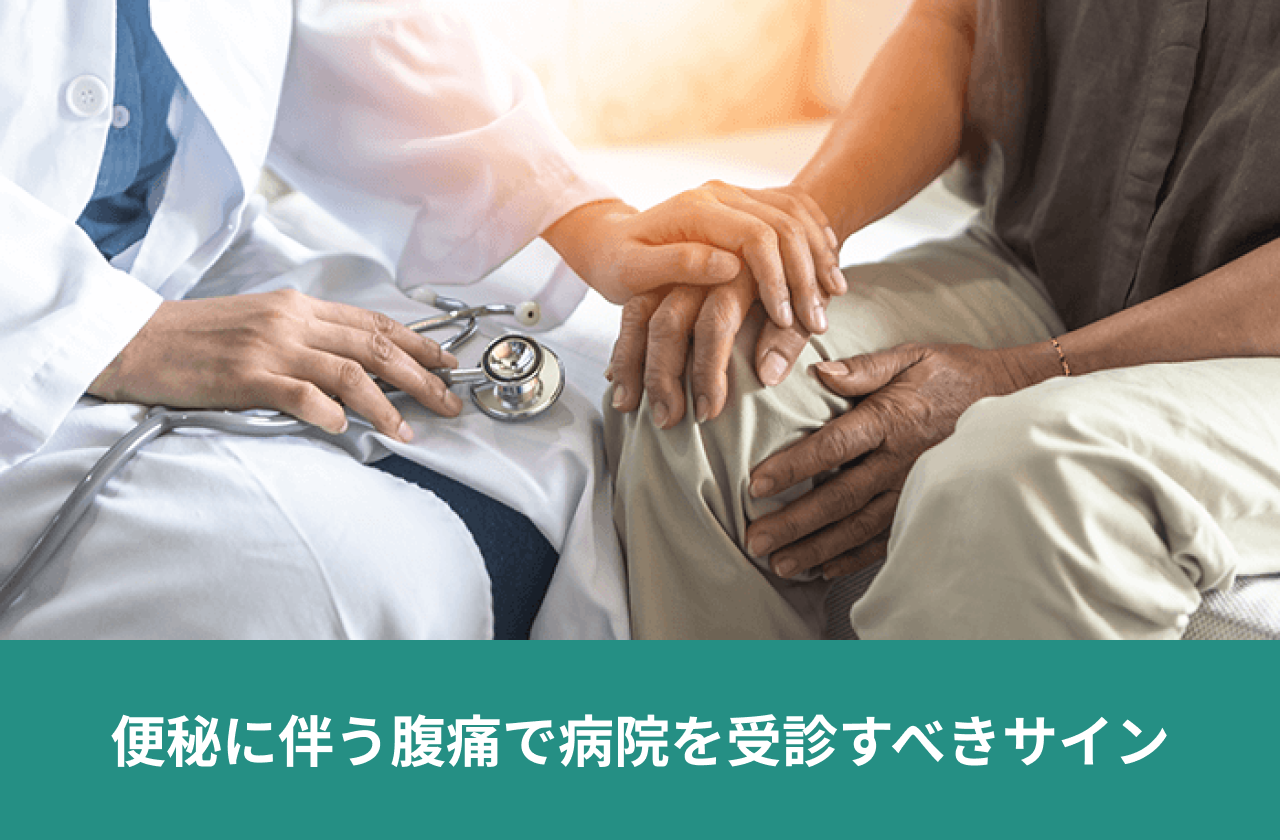 便秘に伴う腹痛で病院を受診すべきサイン。患者の手に手を添えて診察する医師。