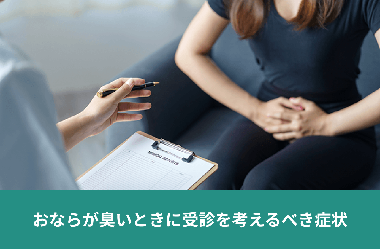 おならが臭いときに受診を考えるべき症状。腹部を押さえる患者から話を聞く診察場面。