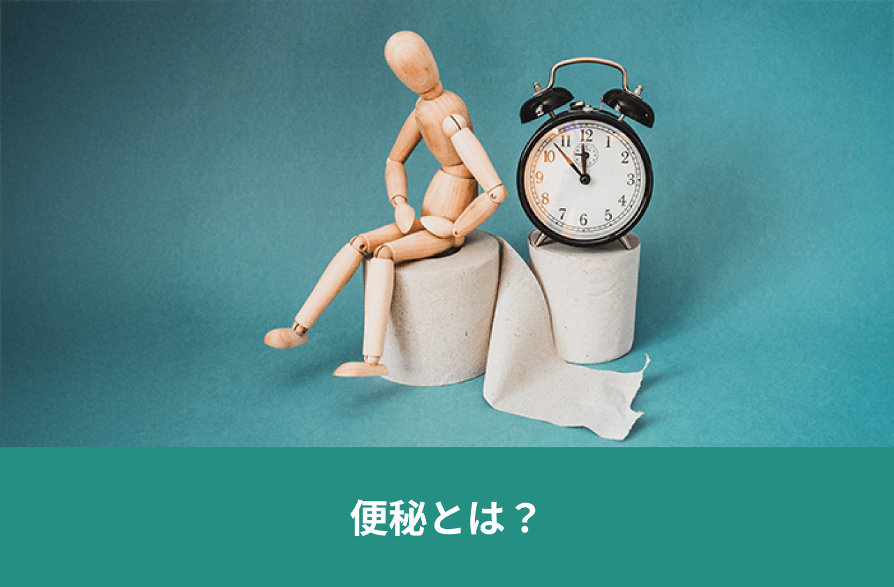 便秘とは？。便座に座る人形と時計。