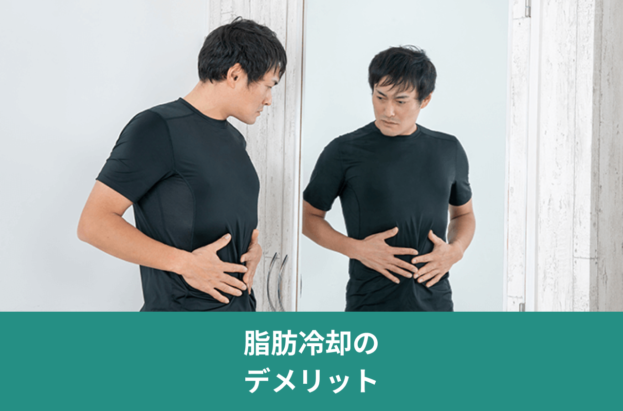 脂肪冷却のデメリット。鏡に映る自分の腹部を確認する男性の写真。