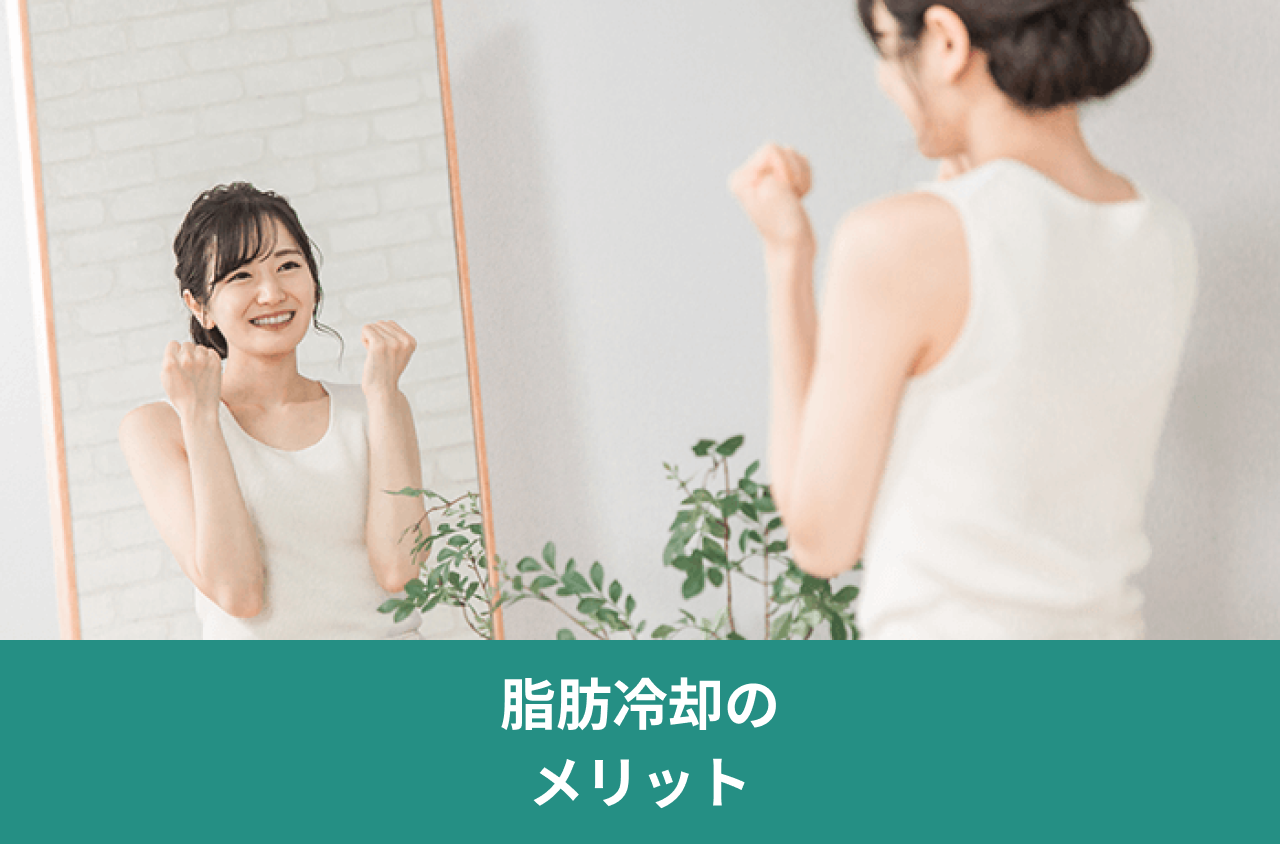 脂肪冷却のメリット。鏡の前で両手を握って笑う女性の写真。